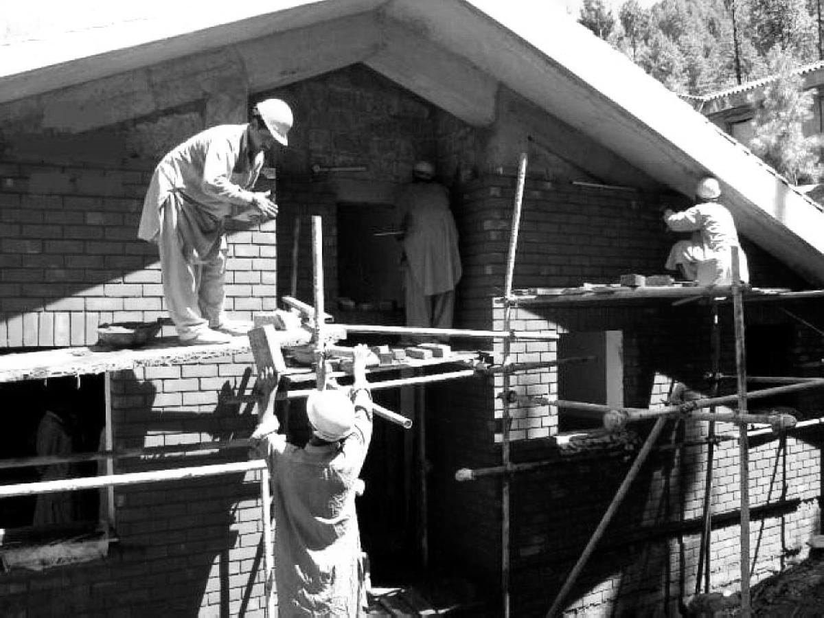 Construction workers build a house.
